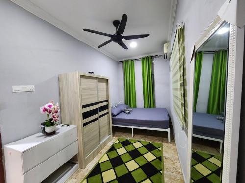 a bedroom with two beds and a ceiling fan at MK Homestay in Butterworth