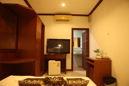 a room with a bed and a television in a room at New Forest Patong in Patong Beach