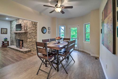 a dining room with a table and a stone fireplace at Near Sugar Mtn Resort! Mtn-View Outdoor Basecamp in Banner Elk
