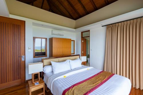 a bedroom with a large bed in a room at Moritz Palm Villa in Uluwatu