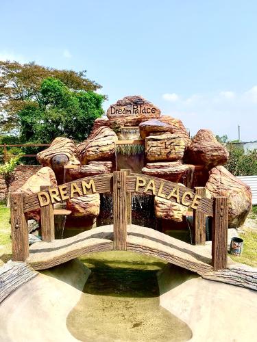 a wooden bench in front of a stack of rocks at Dream Palace Resort in Kathmandu