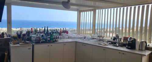 a bar with a large window with a view of the city at Room in Studio - One Room Private Suite in Hersonissos