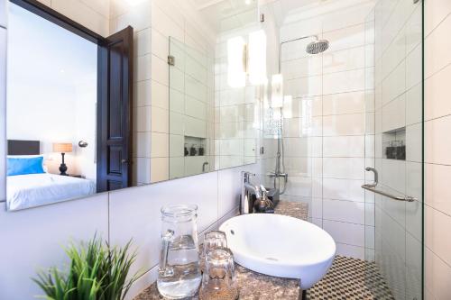 La salle de bains est pourvue d'un lavabo et d'un miroir. dans l'établissement Villa Rua - Stylish luxury, tranquil location in Legian, walk to beach, à Seminyak