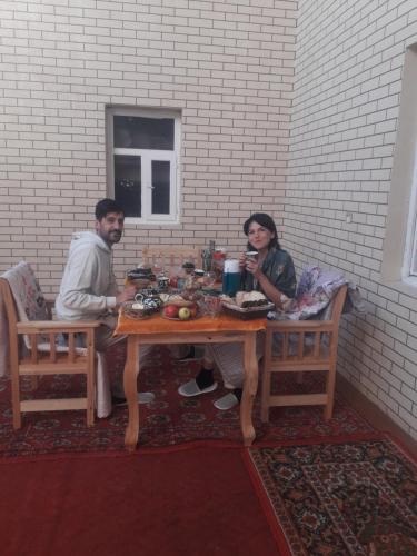 a man and a woman sitting at a table at Hotel Allanazar Ota in Khiva