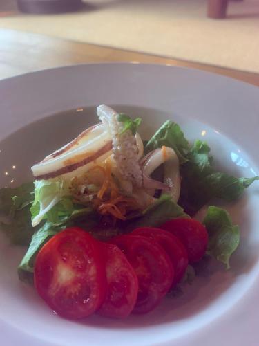 a white plate of food with tomatoes and lettuce at 島宿糸 in Iki