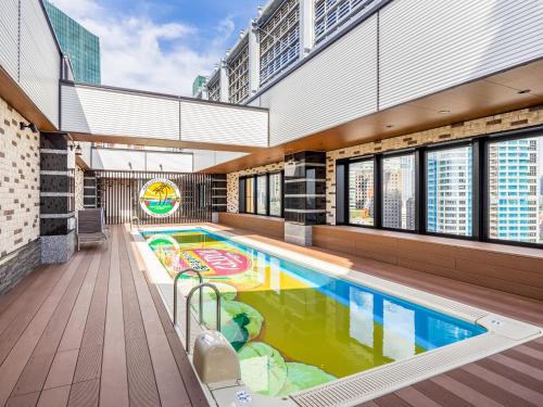 APA Hotel & Resort Roppongi-Eki-Higashi في طوكيو: مسبح كبير في مبنى به مبنى