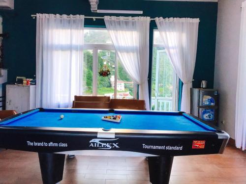 a blue pool table in a living room with curtains at Nhà Trên Mây - Homstay Tam Đảo in Tam Ðảo