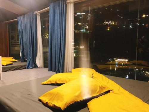 Nhà Trên Mây - Homstay Tam Đảo في تام داو: مظلة صفراء على سرير في غرفة مع نافذة