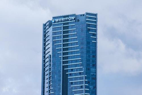 a building with a sign on the top of it at Meriton Suites Adelaide Street, Brisbane in Brisbane