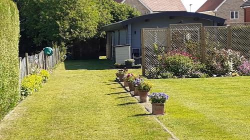 a garden with potted plants on the grass at The Annexe, Cornfields in Elmswell