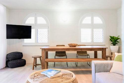 a living room with a table and a tv at The Terraces Main Beach in Byron Bay
