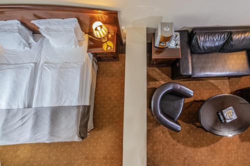 a bedroom with a bed and a chair and a desk at La Contessa Castle Hotel in Szilvásvárad