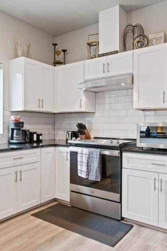 a white kitchen with white cabinets and an oven at Full ADA Unit - 2 Bed 2 Bath Unit Near Downtown in Spokane