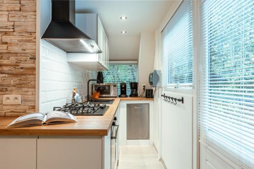 a kitchen with a stove top oven next to a window at Le Petit Renard in Durbuy