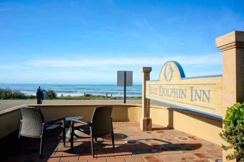 a sign for the dolphin inn with chairs and the ocean at Blue Dolphin Inn in Cambria