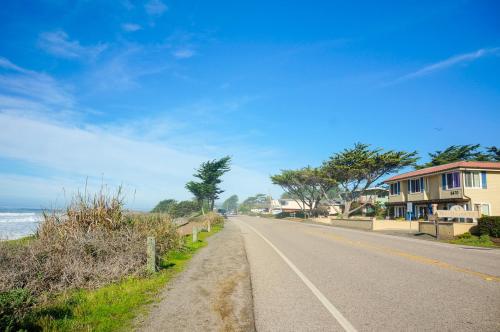an empty road next to a beach with houses at Blue Dolphin Inn in Cambria