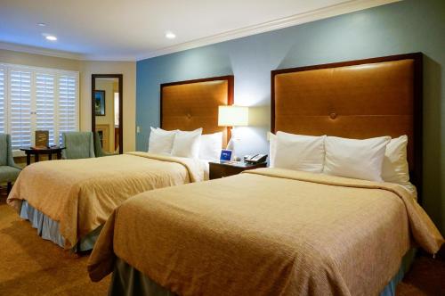 a hotel room with two beds and a table with a lamp at Blue Dolphin Inn in Cambria