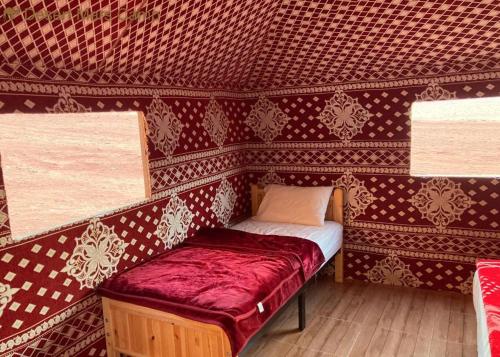 a small room with a small bed in a wall at Wadi Rum Nights in Wadi Rum