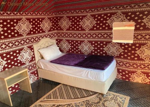 a small bed in a room with a wall at Wadi Rum Nights in Wadi Rum