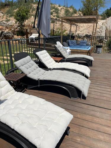 a bunch of pillows sitting on a wooden deck at Vibe Naftali Estate in Ramot Naftali