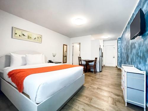 Dormitorio blanco con cama y mesa en Casa Pellegrino Boutique Hotel, en Hollywood