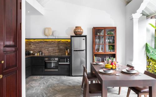 a kitchen with a table and a refrigerator at Villa Tahi - Stylish luxury, tranquil location, walk to beach in Legian