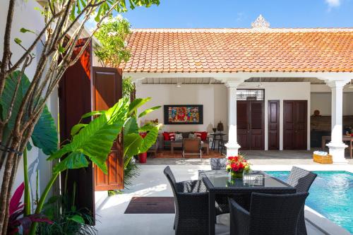 a patio with a table and chairs next to a pool at Villa Tahi - Stylish luxury, tranquil location, walk to beach in Legian