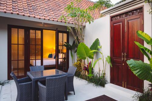 a patio with a table and chairs in front of a house at Villa Tahi - Stylish luxury, tranquil location, walk to beach in Legian