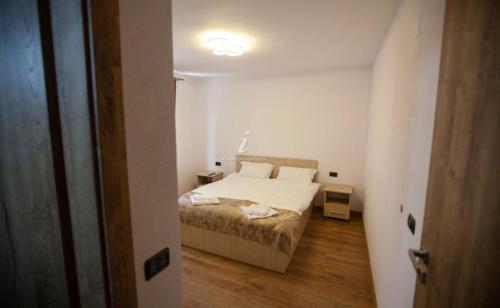a small bedroom with a bed and a hallway at Casa Diana Rasnov in Râşnov