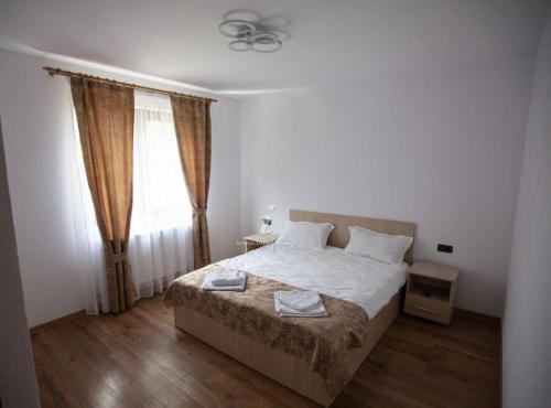 1 dormitorio con cama y ventana en Casa Diana Rasnov, en Râșnov