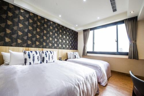a hotel room with two beds and a window at Red hotel in Yuanlin