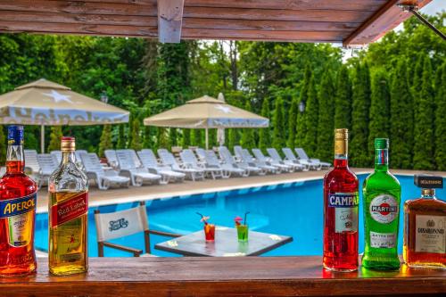 four bottles of alcohol sitting on a table near a swimming pool at La Contessa Castle Hotel in Szilvásvárad