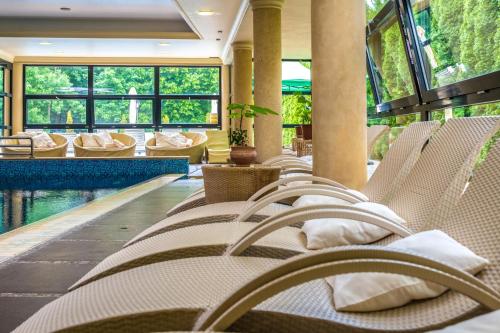 a row of chairs in a hotel lobby with a pool at La Contessa Castle Hotel in Szilvásvárad