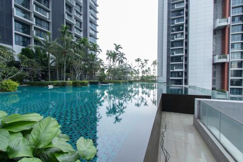 een zwembad in het midden van twee hoge gebouwen bij Grand Medini Residence @ UHA in Nusajaya