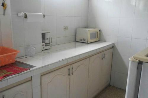 una cocina con microondas en la parte superior de un mostrador en Edificio El Constructor Apartamento Independiente, en Guayaquil