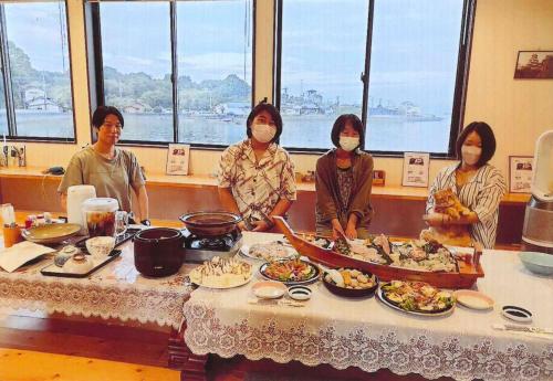 a group of women standing around a table with food at Minshuku Hiro - Vacation STAY 84405v in Kami Amakusa