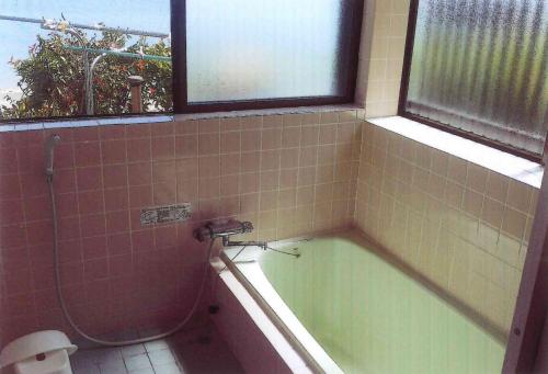 a bathroom with a tub and a toilet and windows at Minshuku Hiro - Vacation STAY 84405v in Kami Amakusa