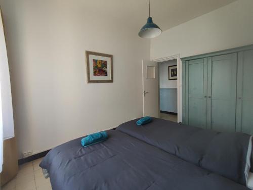1 dormitorio con 1 cama con manta azul en Le Cottage Malouin, en Dunkerque