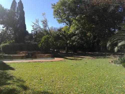 un parque con césped verde y árboles al fondo en Home away from Home (Lakefield), en Benoni