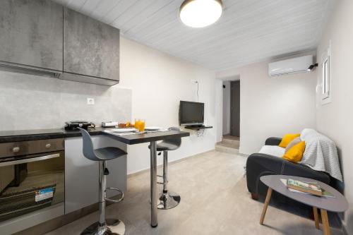 a kitchen and living room with a desk and a couch at Ileana-Marina studio 1 in Benitses