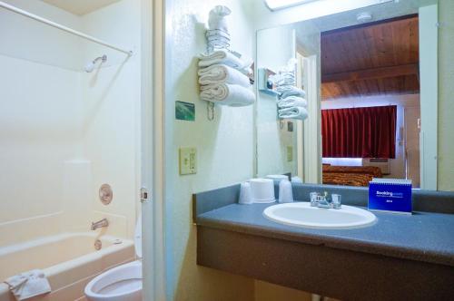 La salle de bains est pourvue d'un lavabo, de toilettes et d'une baignoire. dans l'établissement EZ 8 Motel San Jose I, à San José