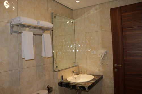 W łazience znajduje się umywalka i lustro. w obiekcie Horison Sentani w mieście Ifaar