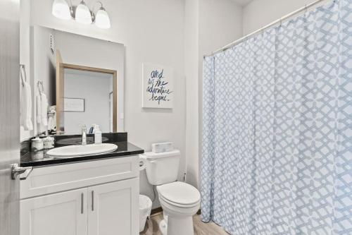 y baño con aseo y cortina de ducha. en New 2 Bed 2 Bath Near Perry Dist and Downtown, en Spokane