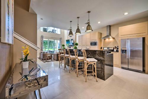 a kitchen with a bar with chairs and a counter top at Upscale Townhome Close to Walt Disney World! in Orlando