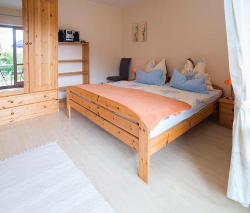 Un dormitorio con una gran cama de madera con almohadas azules en Ferienwohnung Meisbüsch, en Merzig