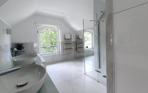 uma casa de banho branca com um lavatório e um chuveiro em Holimo Hotel em Stronie Śląskie