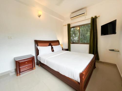 a bedroom with a bed and a window at Rainforest - Casa Del Sol, Anjuna - 3 kms from the beach in Anjuna