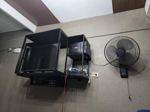 a television and a fan in a room at Palazzo 1 HotSpring,3Bedrooms 35to40pax, Pansol Calamba in Pansol