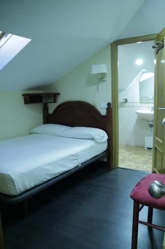 1 dormitorio con 1 cama y baño con lavamanos en Hotel Pizarro, en Humanes de Madrid