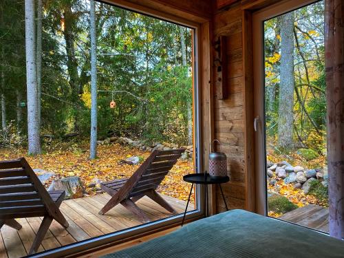 a screened in porch with two chairs on a deck at Ennu’s hut in Loksa